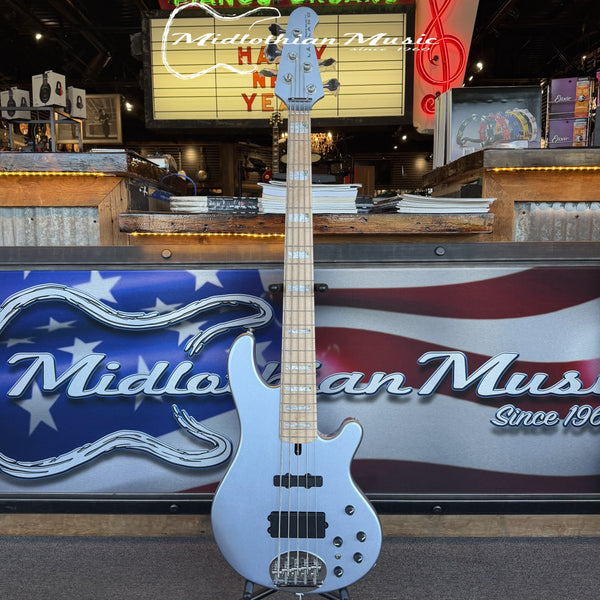 Electric bass guitar displayed in front of a store sign with 'Midlothian Music' branding.