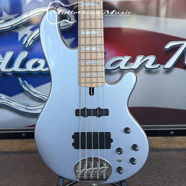 Silver bass guitar with a visible brand logo in the background
