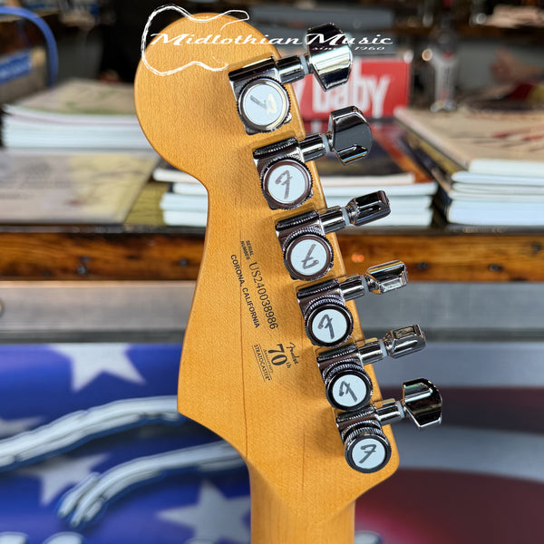 Guitar headstock with tuning pegs on a blurred background